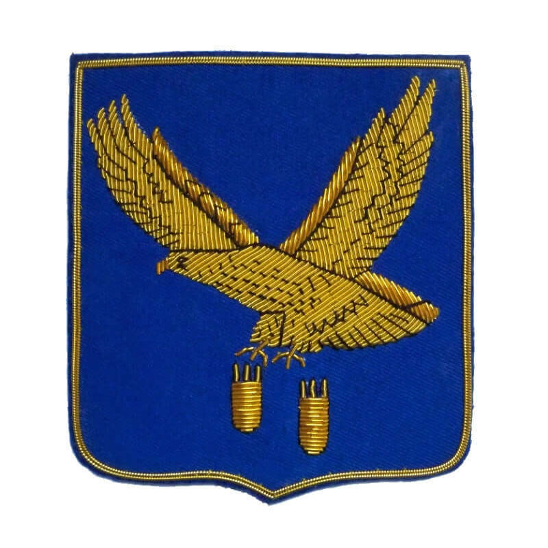Blue rectangle shaped patch with flying gold eagle dropping two bombs from claws