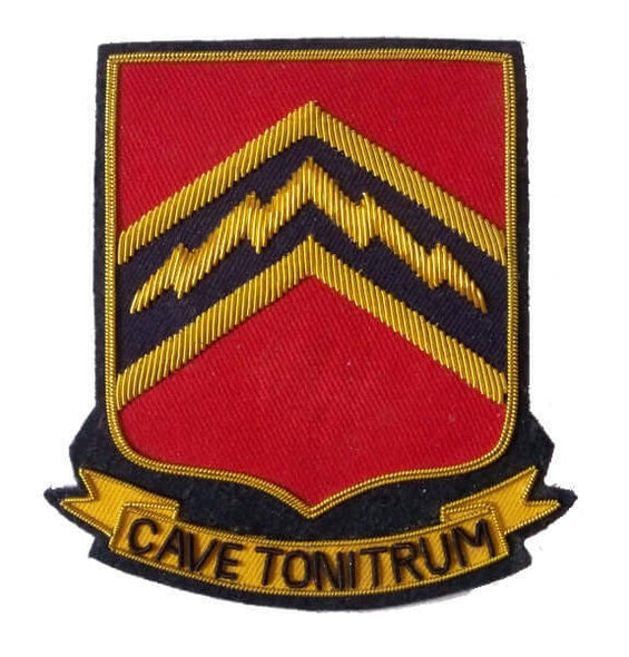 Red rectangle shaped patch with black and gold outer edge. In center is dark blue panel with gold flash. Ribbon along bottom of patch with words 'Cave Tonitrum'