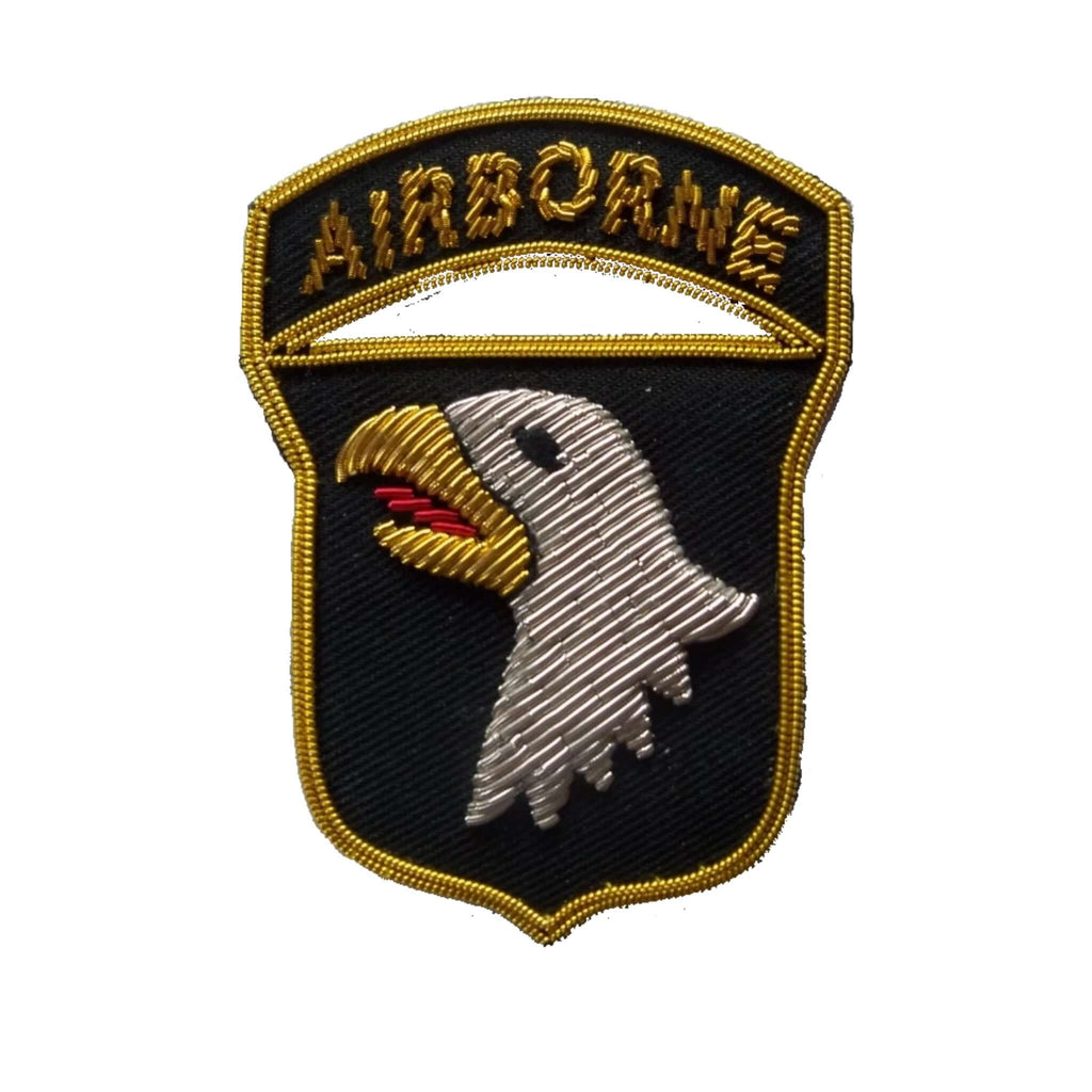 Shield shaped patch with head of bald eagle and top banner embroidered with word Airborne