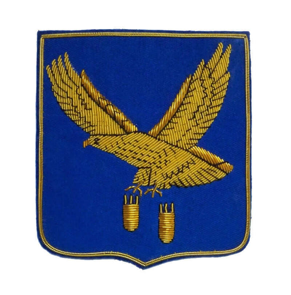 Blue rectangle shaped patch with flying gold eagle dropping two bombs from claws