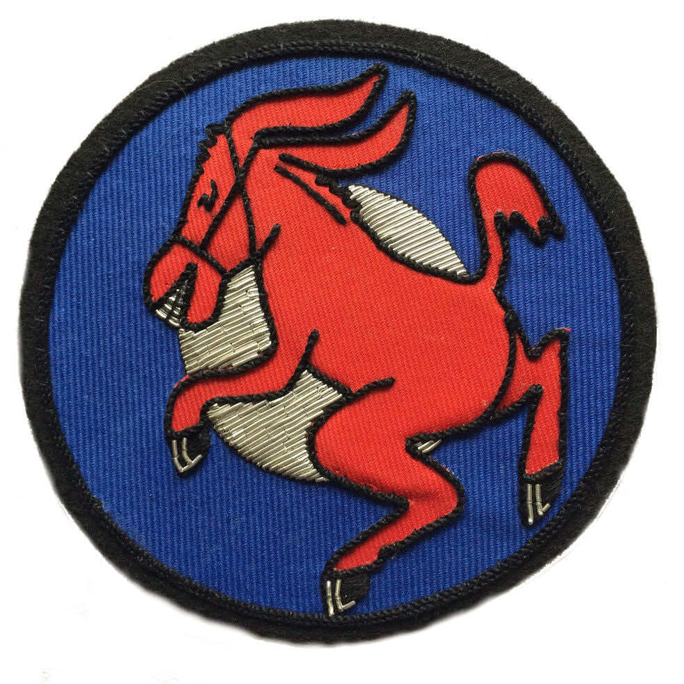 Blue circle shaped patch with silver inner circle.  Red dancing donkey facing right, embroidered in center.