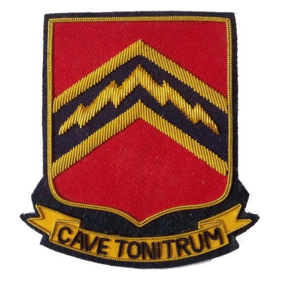Red rectangle shaped patch with black and gold outer edge.  In center is dark blue panel with gold flash.  Ribbon along bottom of patch with words 'Cave Tonitrum'