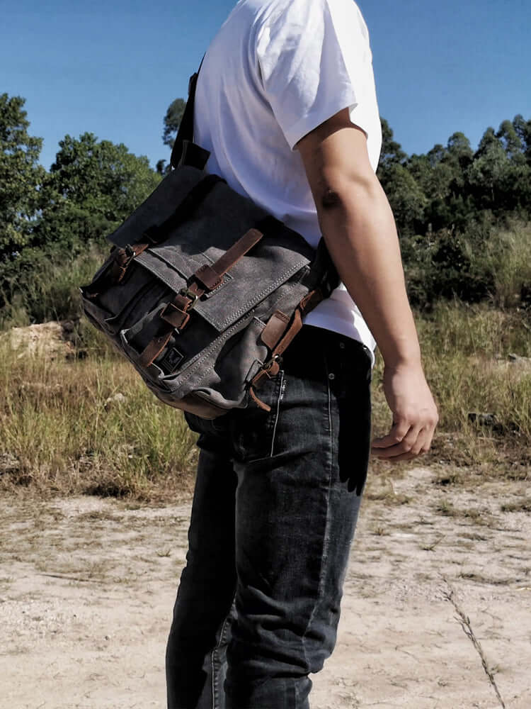 Man wearing the dark grey version of the Canvas and Leather Crossbody Messenger Bag across his body